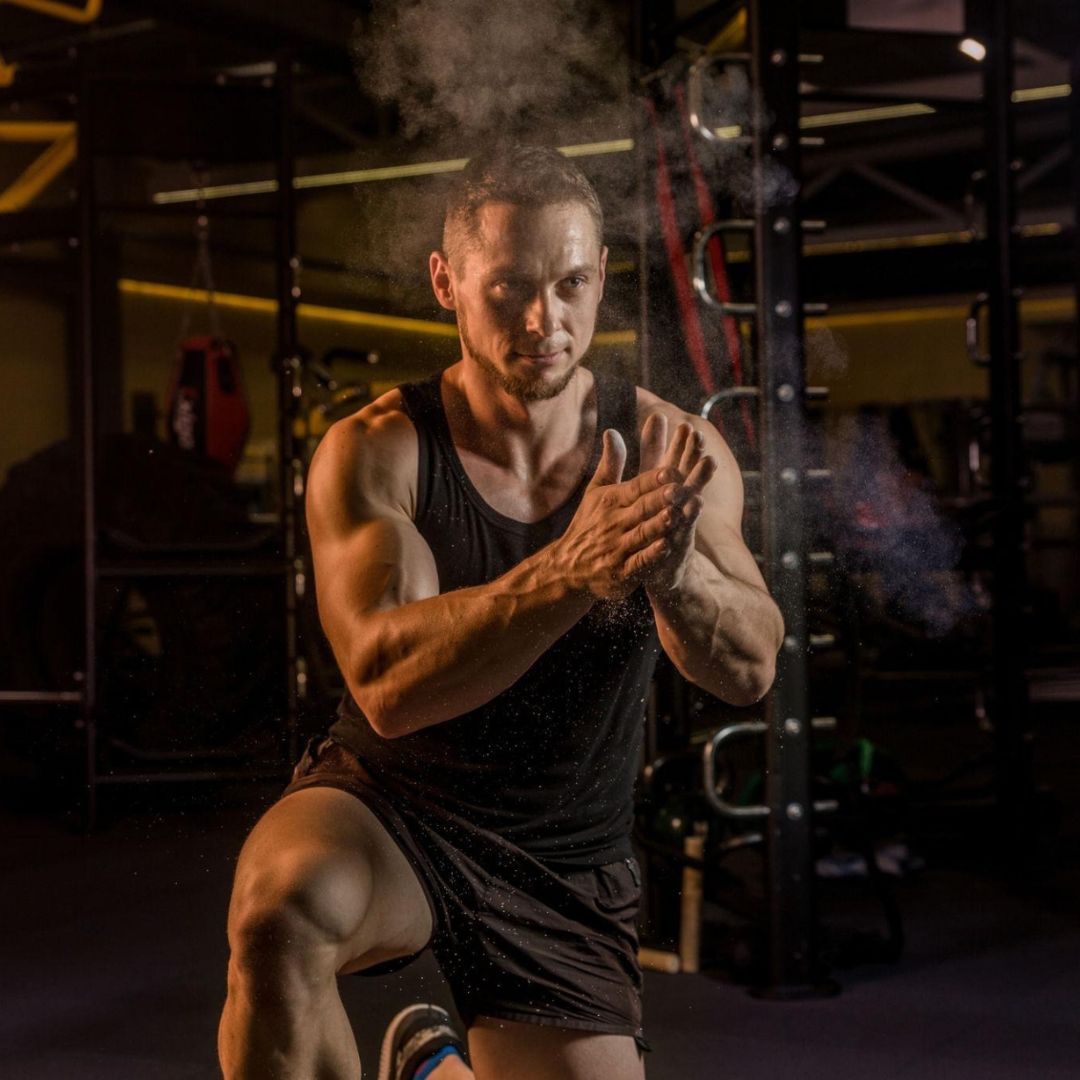 Man in a gym performing a workout with smoke effects